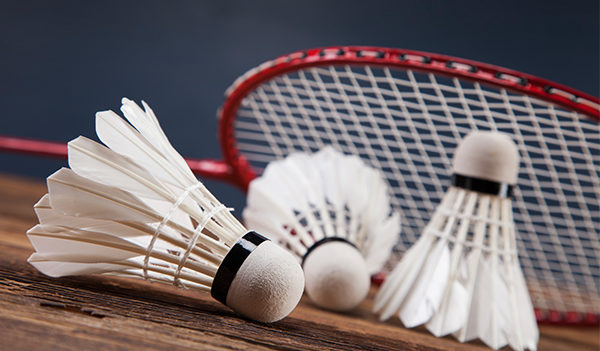 Une raquette de badminton posée sur 3 volants